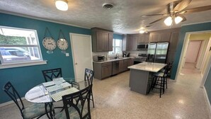 A kitchen with a dining area, granite countertops, and a ceiling fan. - Manatee Cove on the waterway with 5 acres. Pet Friendly. 5 minutes to the beach! (Port St. Joe)