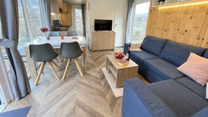 Una sala moderna con un sofá, una mesa de centro y un comedor con sillas y una mesa.