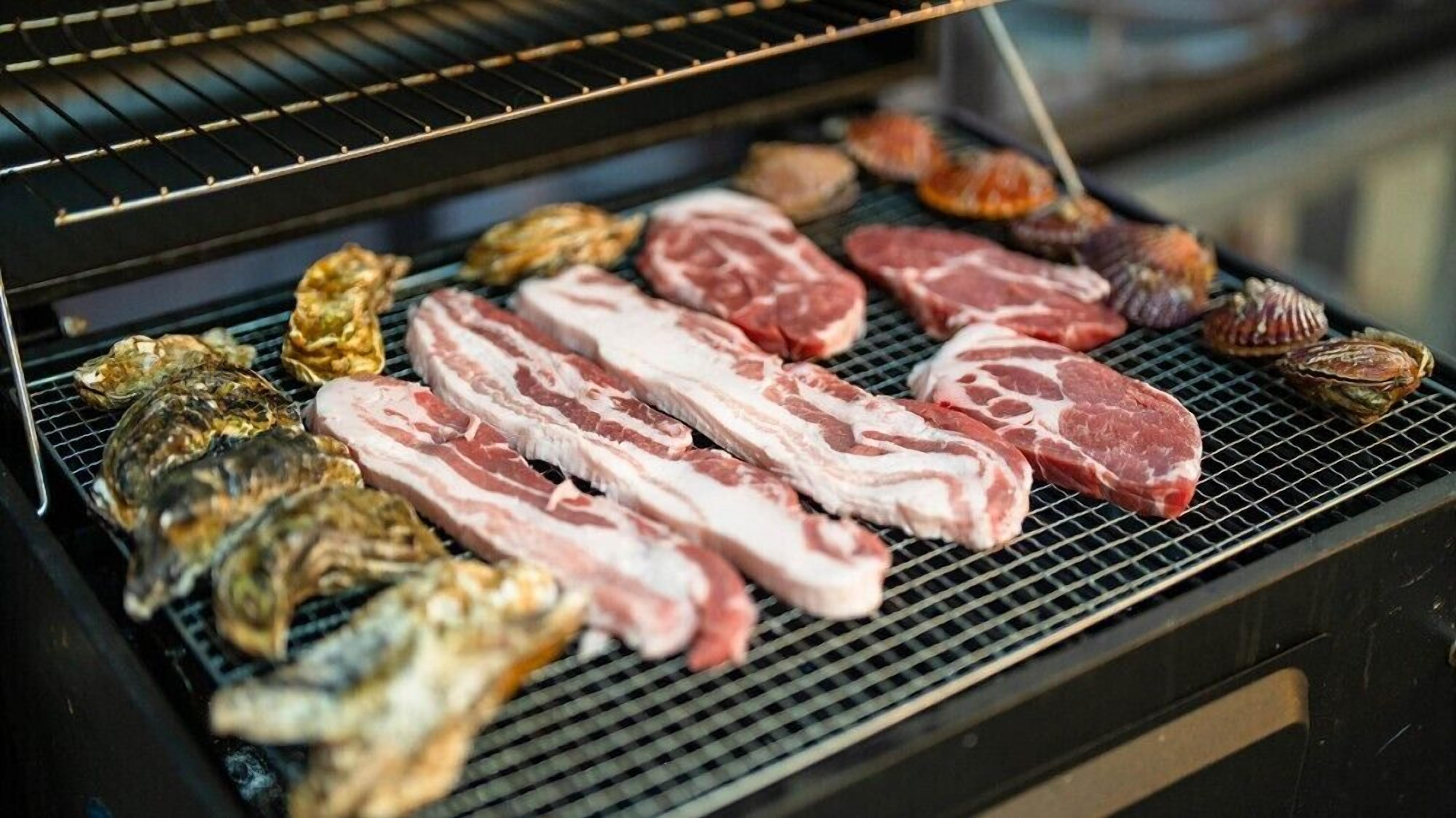 A grill with various meats and seafood.