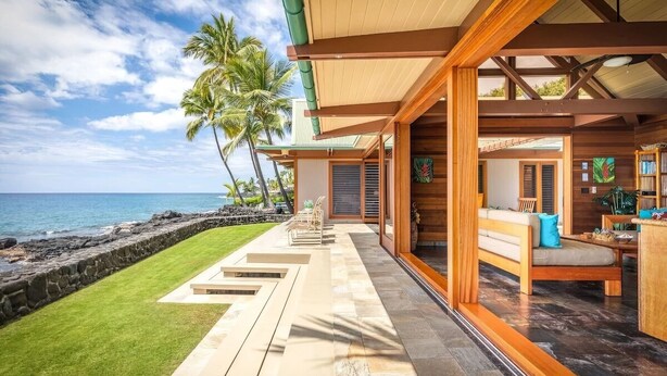 Ein modernes Strandgrundstück mit Terrasse, Holzdeck und Meerblick.