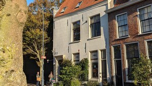 A two-story building with a red-tiled roof, brick facade, and multiple windows. - Het Pakhuis Haarlem - Historic House (Haarlem)