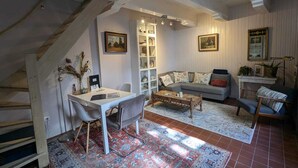 A cozy living room with a sofa, coffee table, and a staircase. - Het Pakhuis Haarlem - Historic House (Haarlem)