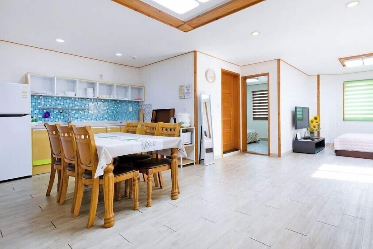 A modern interior with a dining area, kitchen, and bedroom.