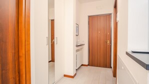 A narrow hallway with wooden doors and a white wall. - Il Roseto - Italian Homing (Desenzano del Garda)