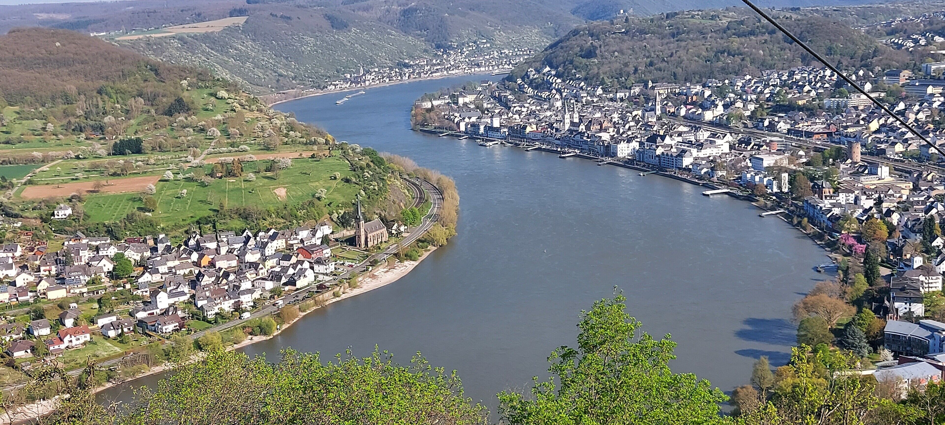 En flod der løber gennem en by med boligområder og en bro.