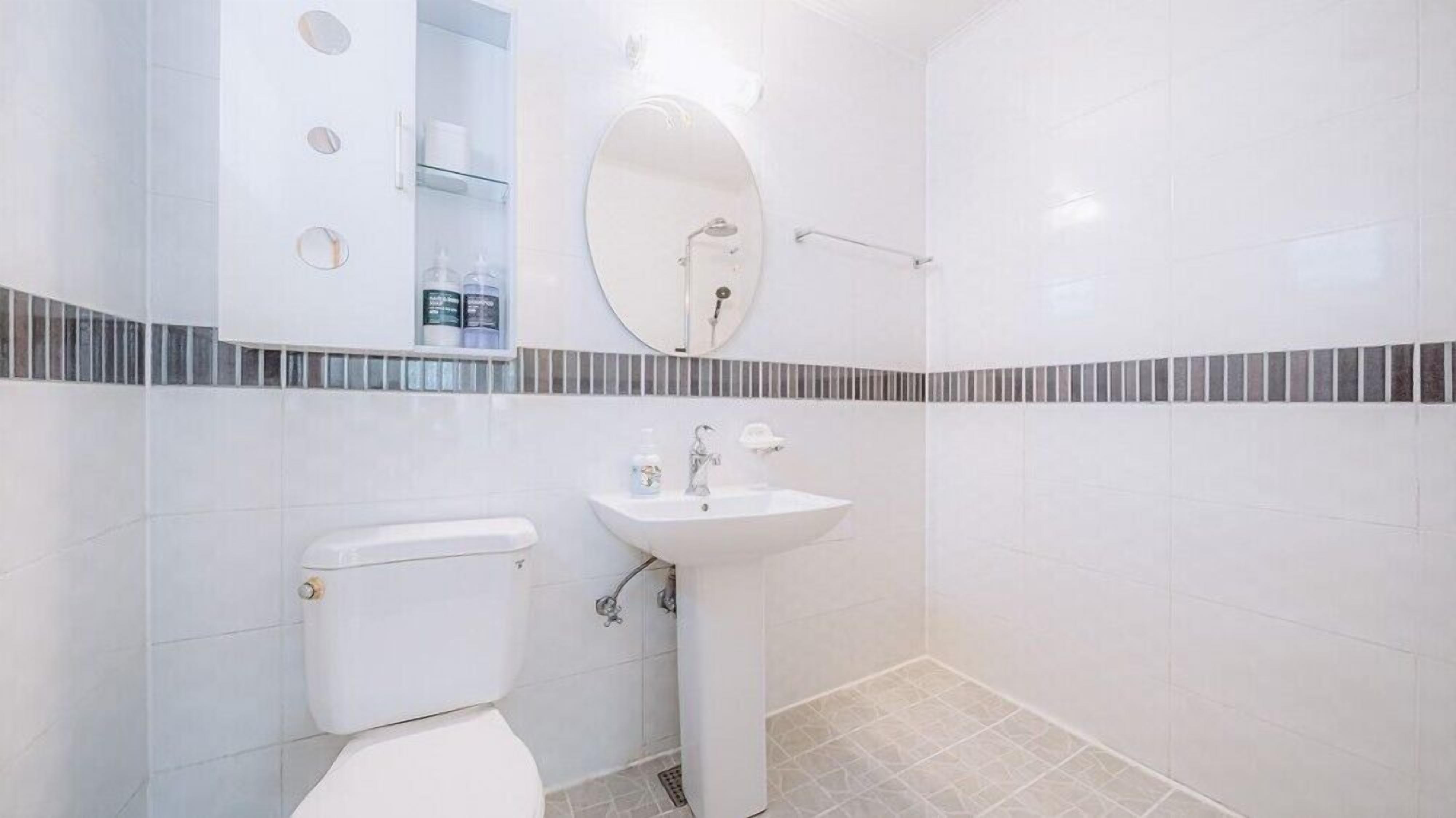 A bathroom with a toilet, sink, and shower.