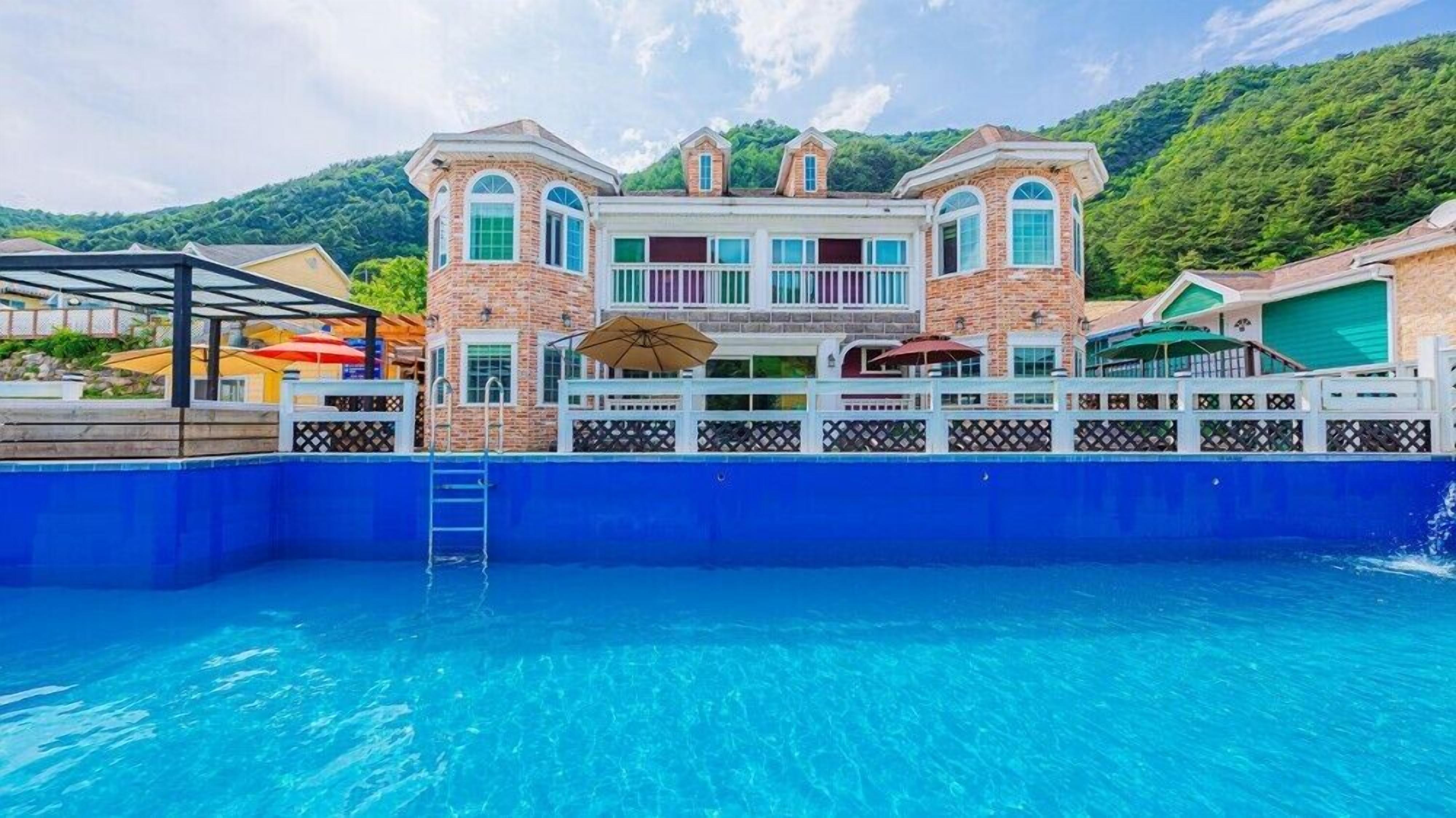 Une grande maison avec une piscine à l’avant.