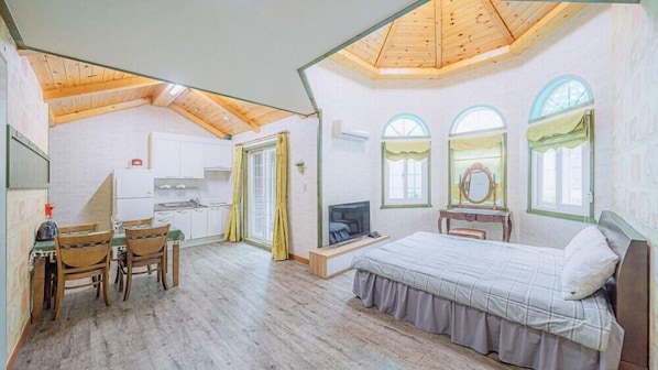 Un dormitorio con techo de madera, una cama, un televisor y un escritorio con una silla.
