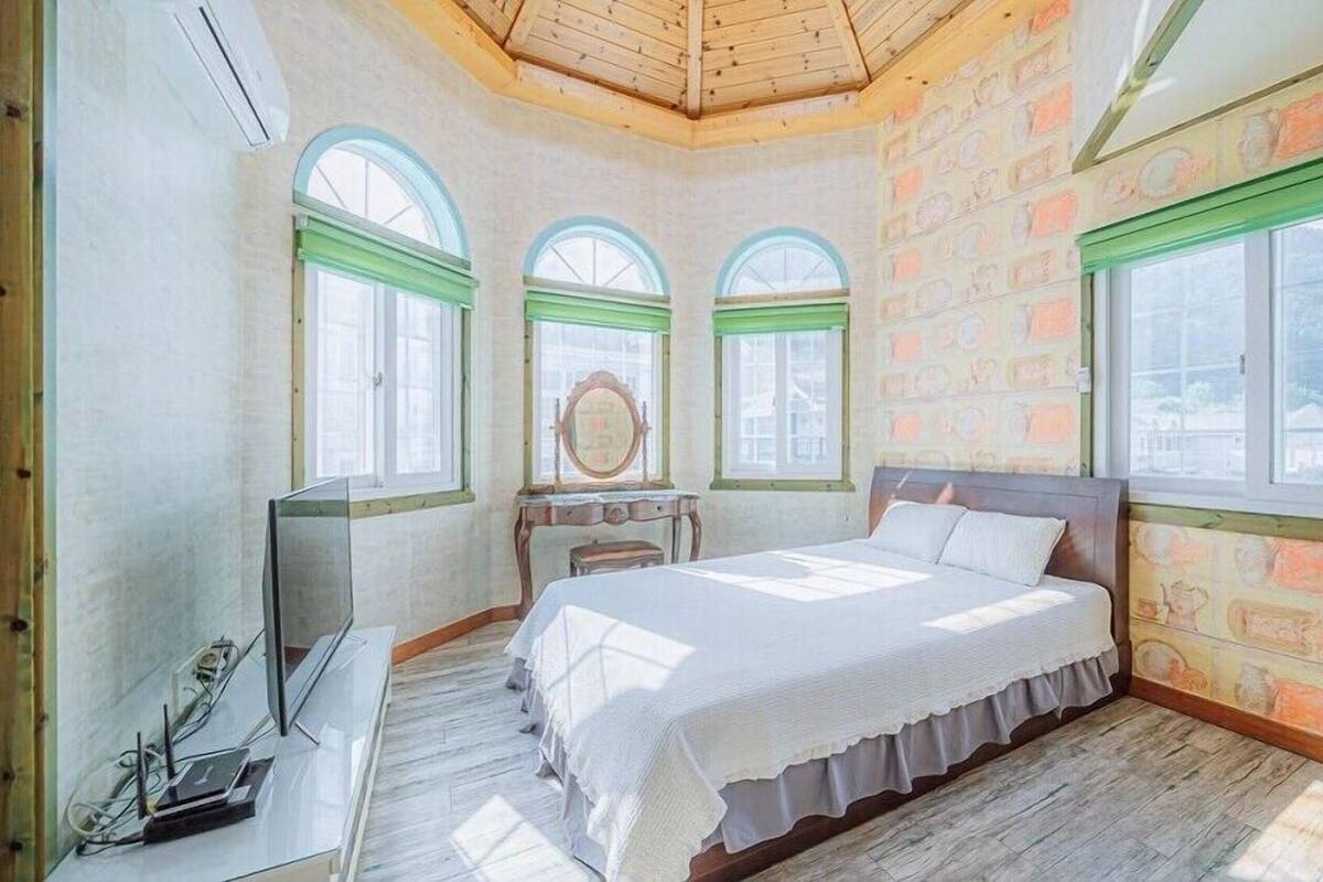 Un dormitorio con cama, cómoda, espejo y ventana.