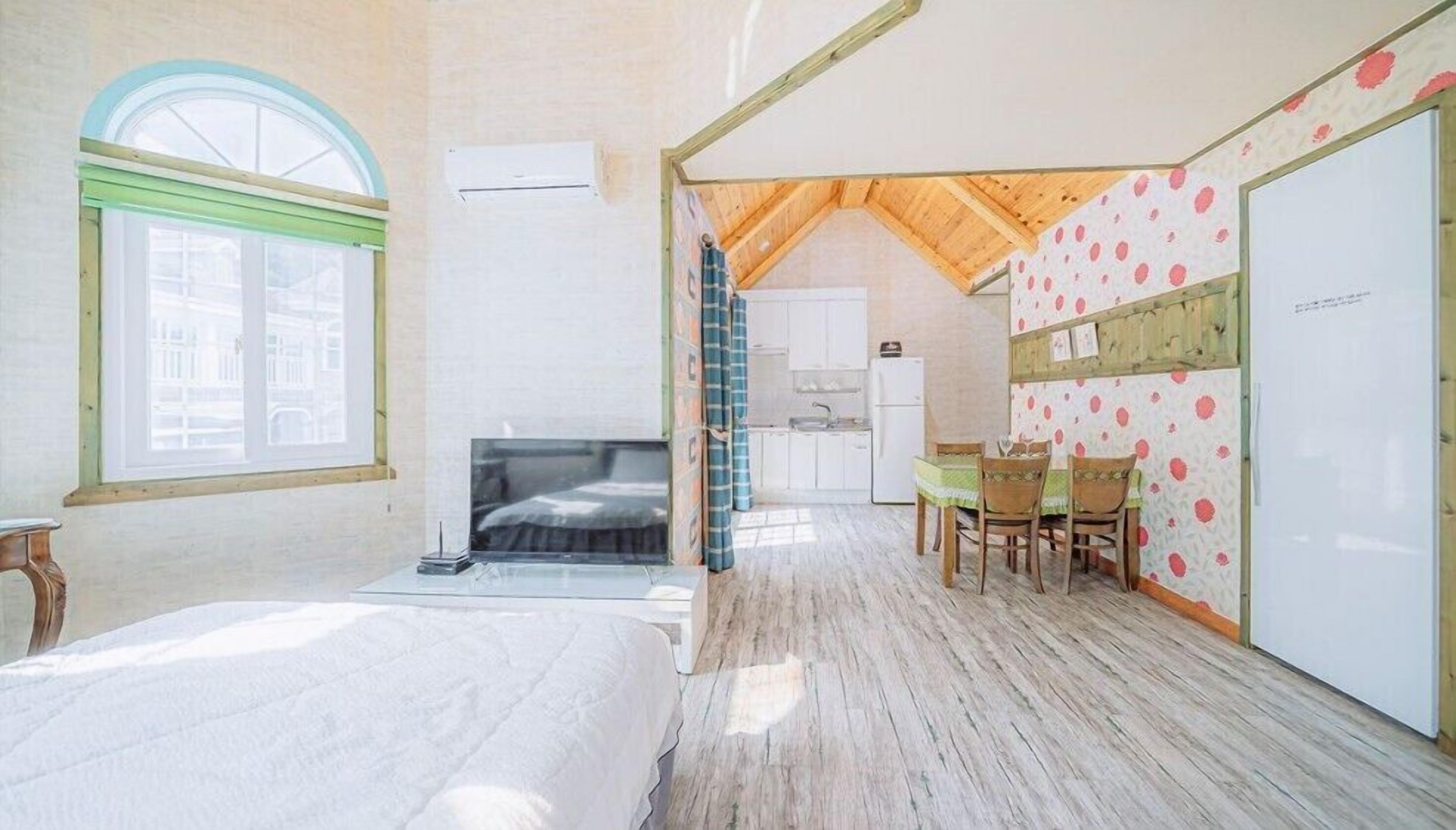 Un dormitorio con una cama grande, una ventana y vistas a un paisaje urbano.