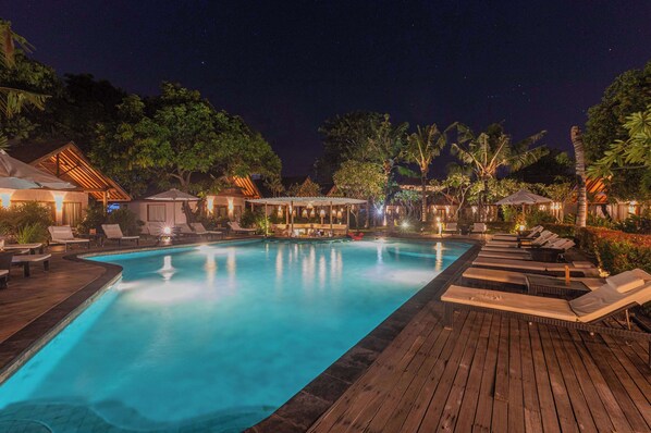 Una piscina al aire libre, sombrillas, tumbonas
