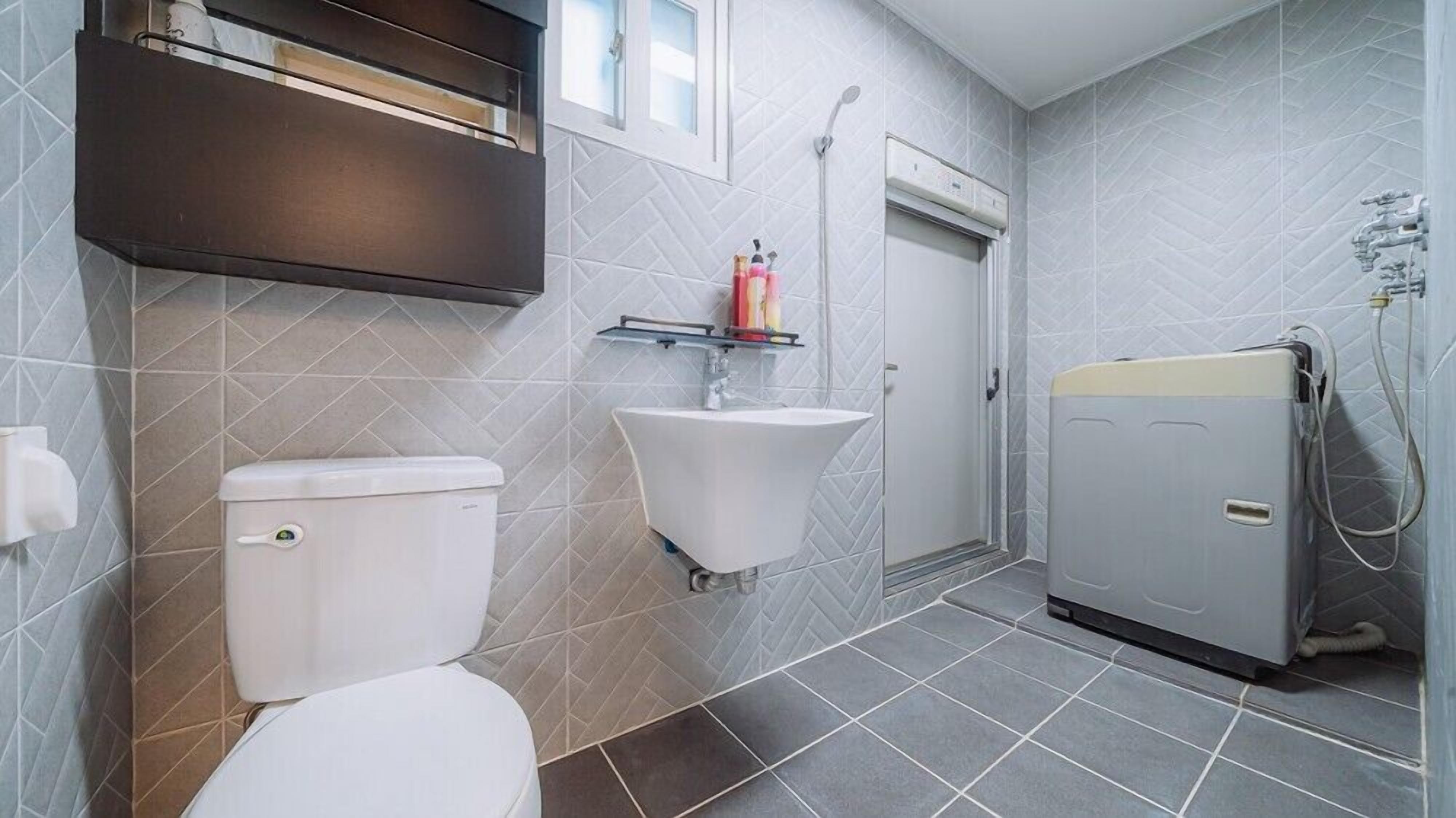 Un baño con inodoro, lavamanos y ducha.