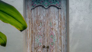 A wooden door with intricate carvings and a traditional design. - Tutik Private House by Supala (Ubud)