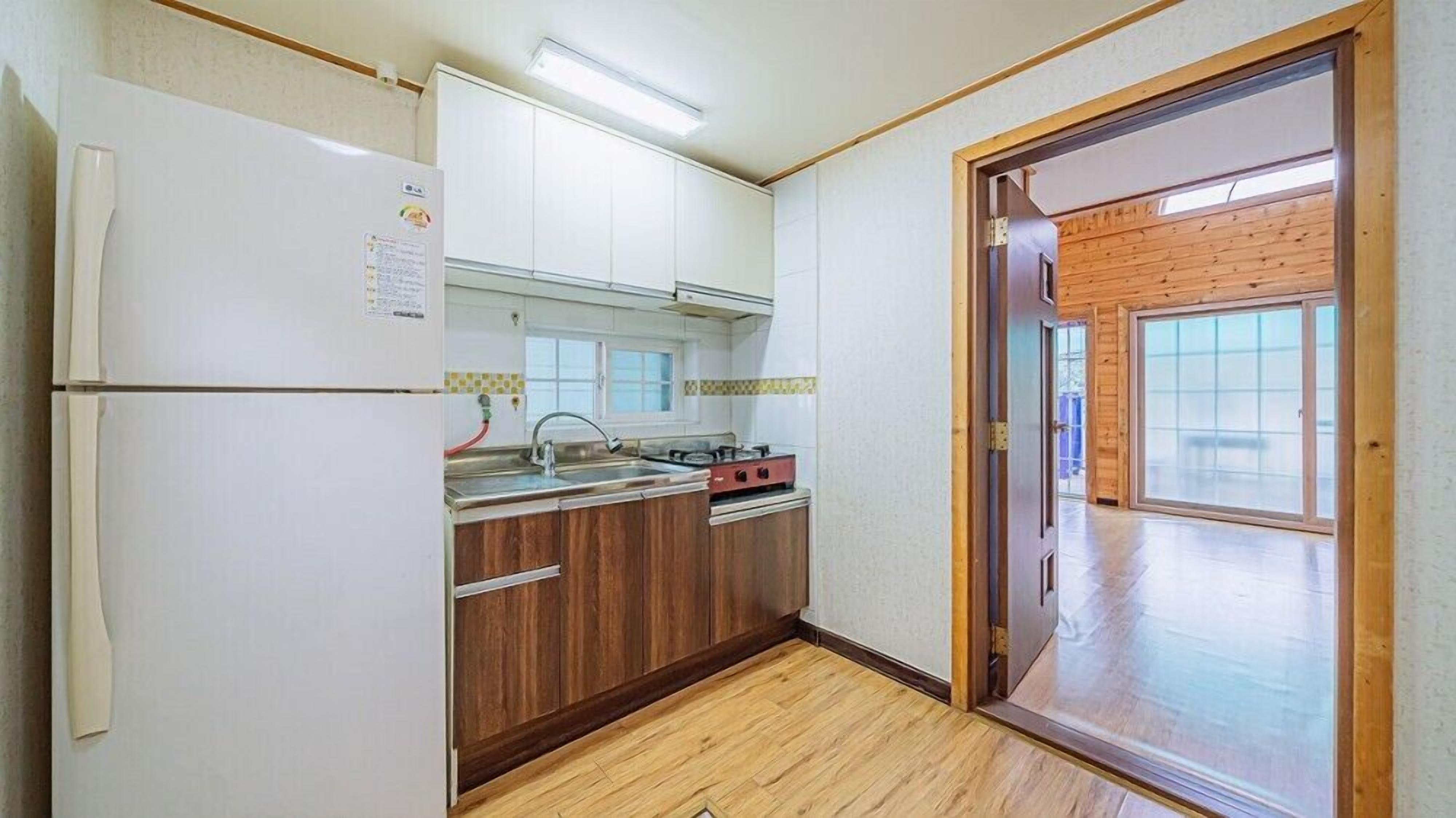 A compact kitchen with a refrigerator, stove, and sink.