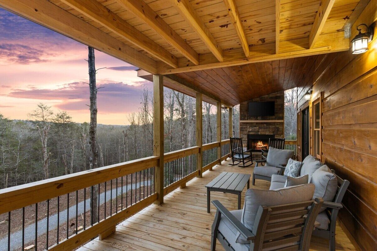 Une terrasse en bois avec des sièges d’extérieur et une cheminée.