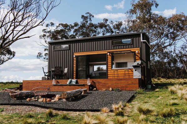 A modern, two-story cabin with a wooden exterior and large windows.