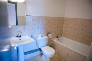 A bathroom with a sink, toilet, and bathtub. - Aux Globe-Trotters (Murat)