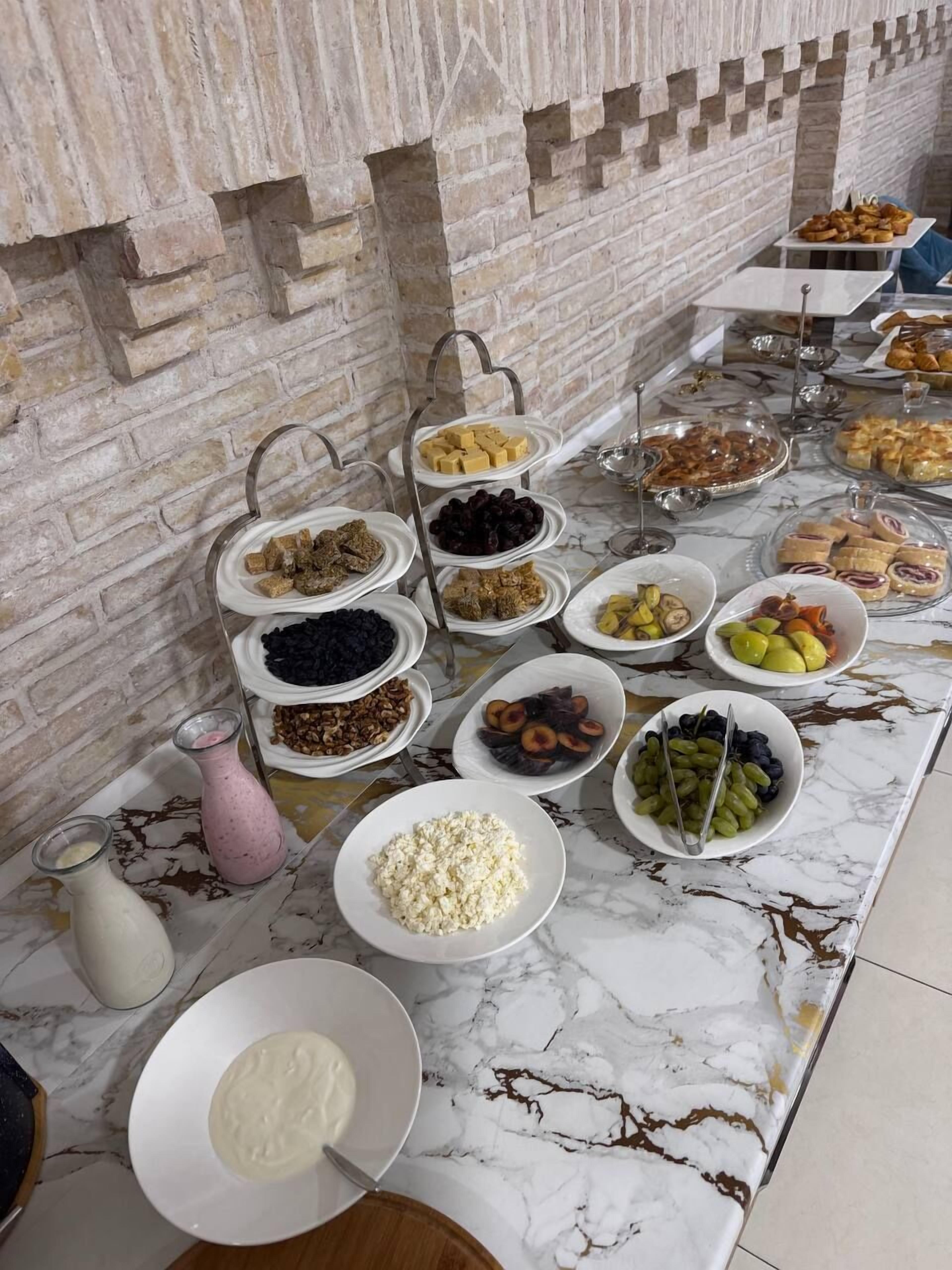 A buffet table with various food items and a marble countertop.