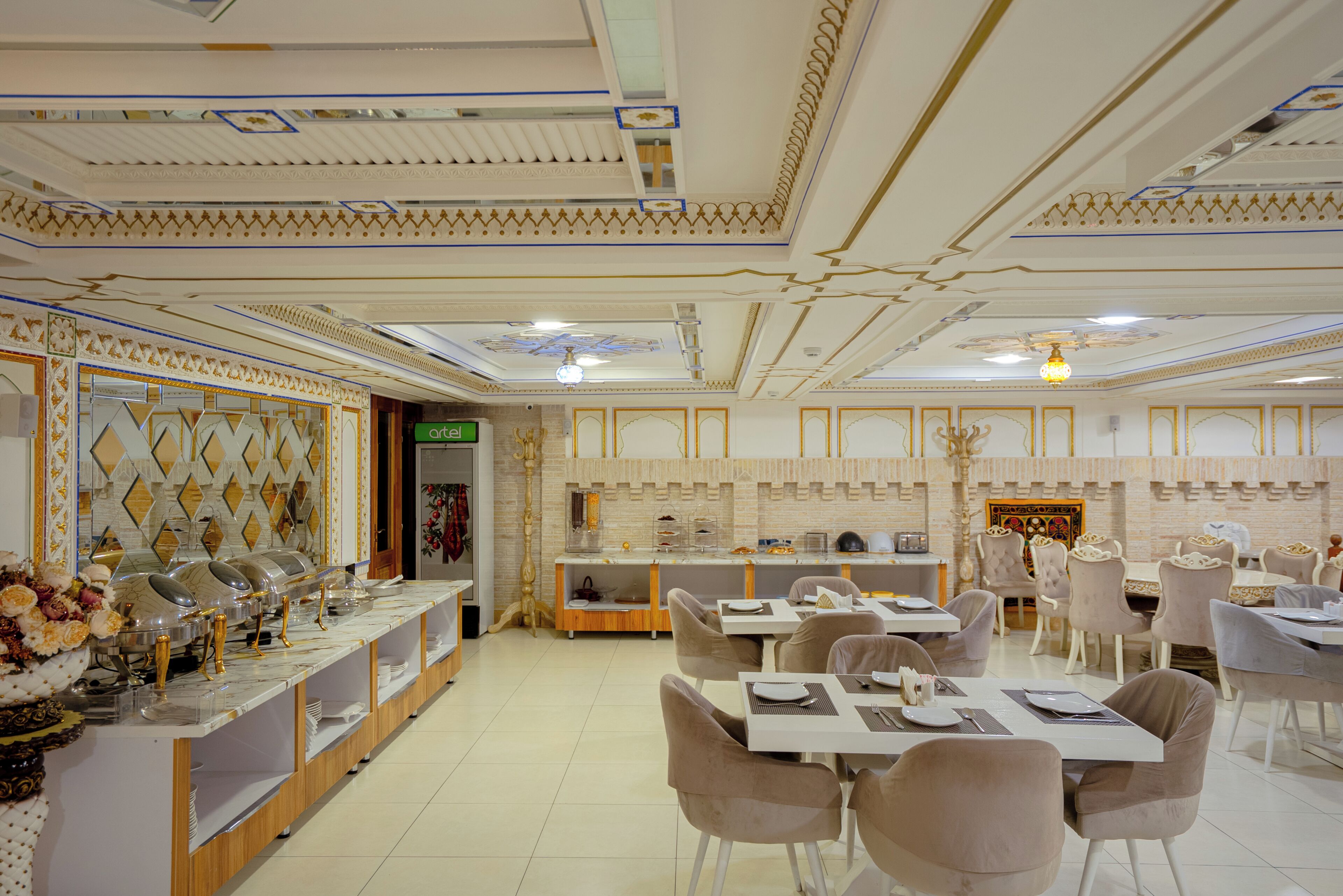 Um restaurante com serviço de buffet, diversas mesas e cadeiras.
