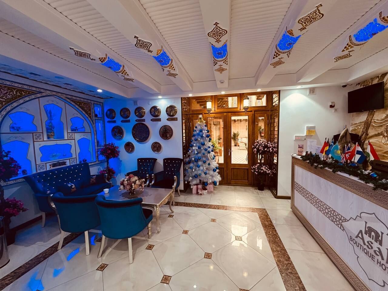 A hotel lobby with a dining area, a Christmas tree, and a reception desk.