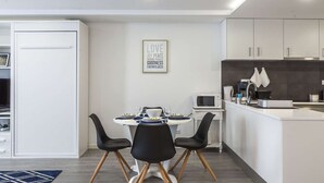 A modern kitchen with white cabinets, a microwave, and a coffee maker.
