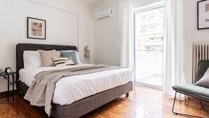 Un dormitorio con cama, mesita de noche y vistas al exterior.