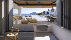 An open-plan living area with a view of the sea, a pool, and outdoor furniture. - Luxurious villa in Paros island. Walking to the beach. Close to Naoussa Town.  (Ιστέρνι)
