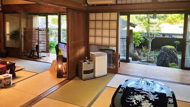 A traditional Japanese room with tatami flooring, sliding doors, a tatami mat table, and a view of a garden. - 107 year old house, 100 year old townhouse. Convenience store, pharmacy, supermarket within 2 minutes walk. Groups of 20 people can stay. Natural hot spring within 5 minutes drive, seafood market, tourist attractions Inuyama Castle and Meiji Village nearb (可児市)
