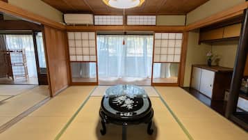 Traditional Japanese room with tatami flooring, shoji screens, and a black lacquered table.