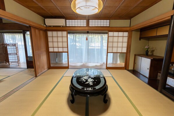 Traditional Japanese room with tatami flooring, shoji screens, and a black lacquered table.