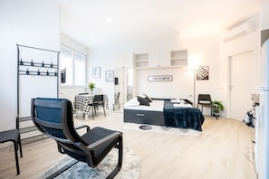 Une chambre moderne comprenant un lit, un bureau, une chaise et une armoire.