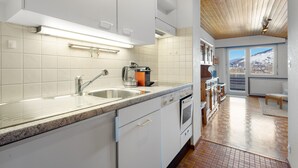 A modern kitchen with white cabinets, a granite countertop, and a built-in oven. - Valaisia 55B - 5 pers - plein centre (Haute-Nendaz)