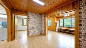 A room with wooden floors, brick walls, and a large window. - Heaven Valley A (Namyangju)