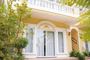 A building with a balcony, large windows with curtains, and a staircase. - Sokchea Kampot Hotel (Kampot)