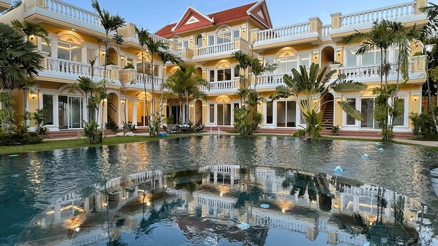 A large, multi-story hotel with a central courtyard featuring a reflective pool. - Sokchea Kampot Hotel (Kampot)