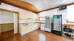 A kitchen with wooden flooring, white cabinets, a built-in microwave, and a refrigerator. - Heaven Valley B (Namyangju)