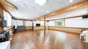 A spacious room with wooden flooring, a television, and a staircase. - Heaven Valley B (Namyangju)