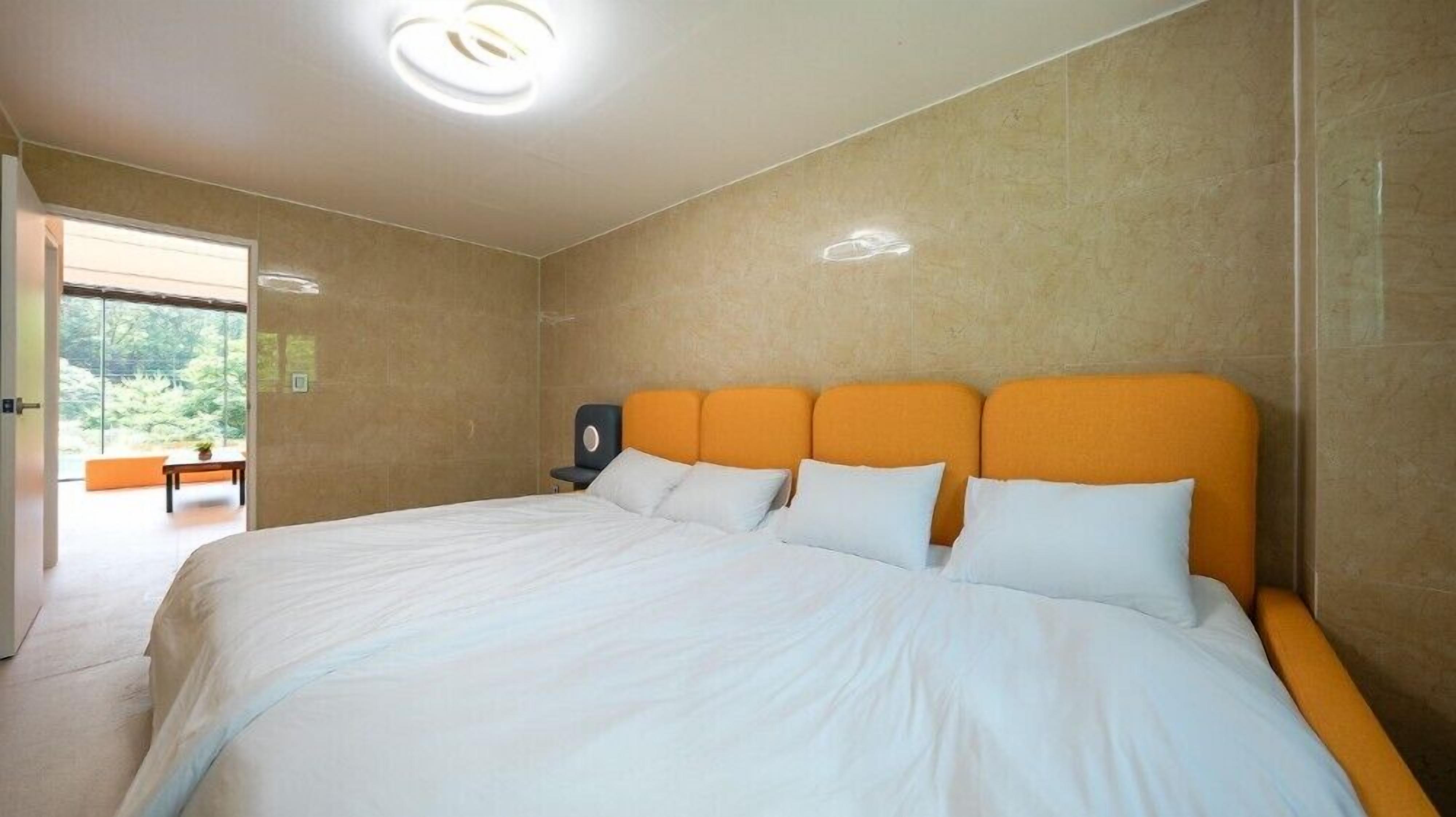 Una camera da letto moderna con un letto grande, una testiera e vista su un balcone.