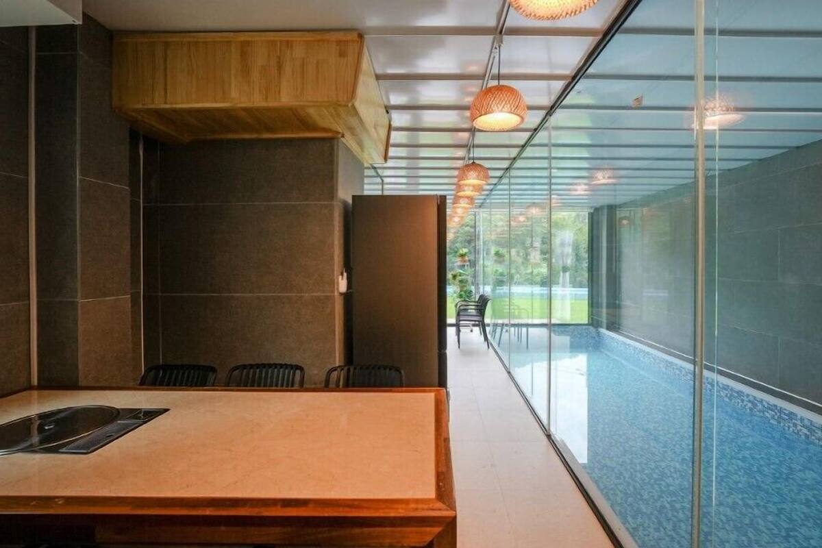 A modern conference room with a glass wall, a wooden table, and chairs.