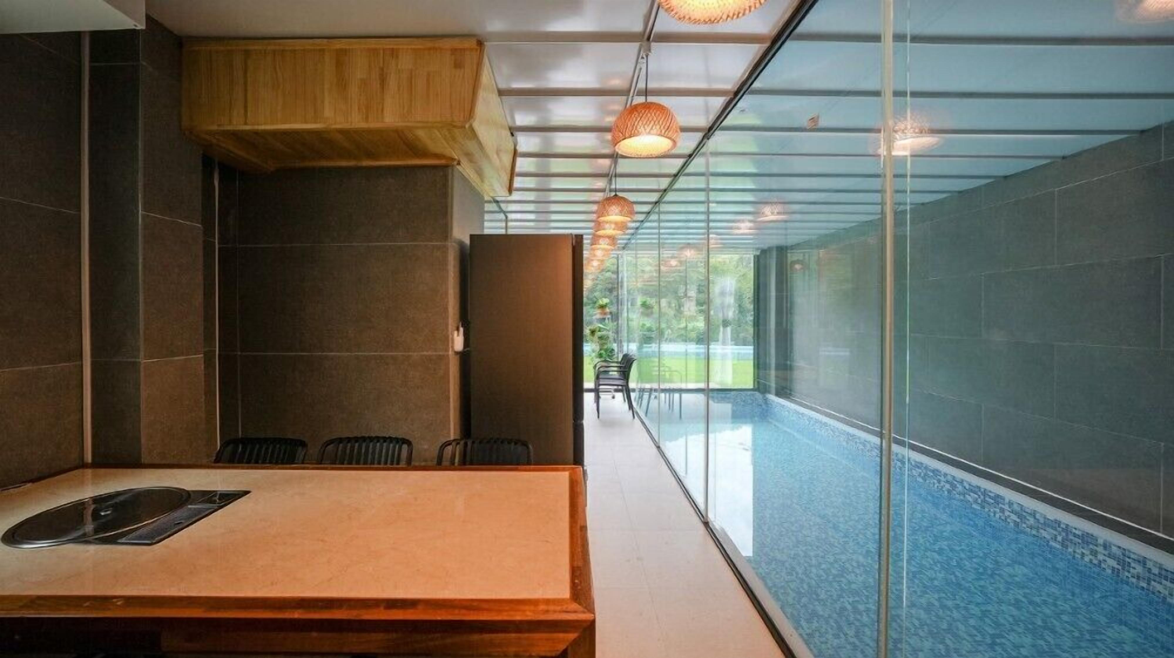 A modern conference room with a glass wall, a wooden table, and chairs.