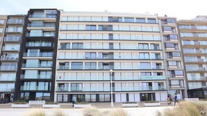 A modern multi-story building with balconies and large windows.