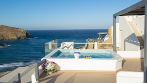 A rooftop pool with a view of the ocean, a staircase, and a flower arrangement. - Myrsini's Luxury Suites (Mykonos)