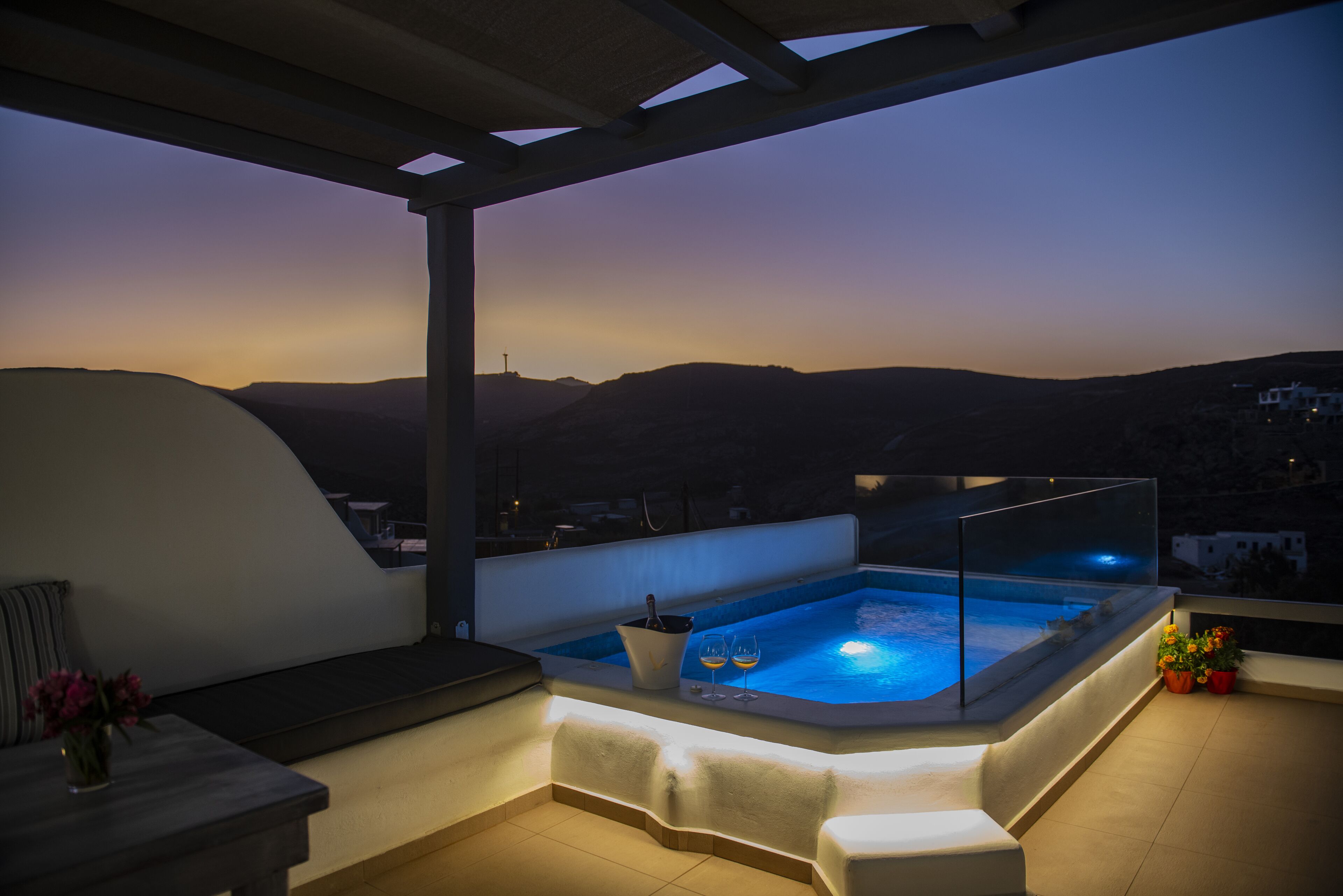A rooftop terrace with a hot tub, seating area, and a view of the mountains.