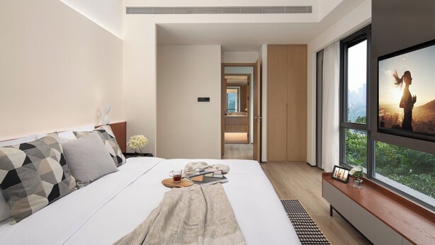 A modern hotel room with a large bed, a TV on the wall, and a view of a cityscape. - Citadines Connect Chayuan Chongqing (Chongqing)