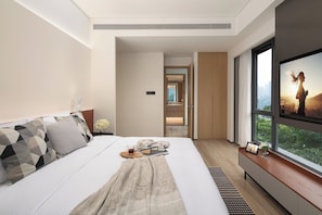 A modern hotel room with a large bed, a TV on the wall, and a view of a cityscape. - Citadines Connect Chayuan Chongqing (Chongqing)