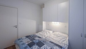 Un dormitorio con cama, armario y puerta.