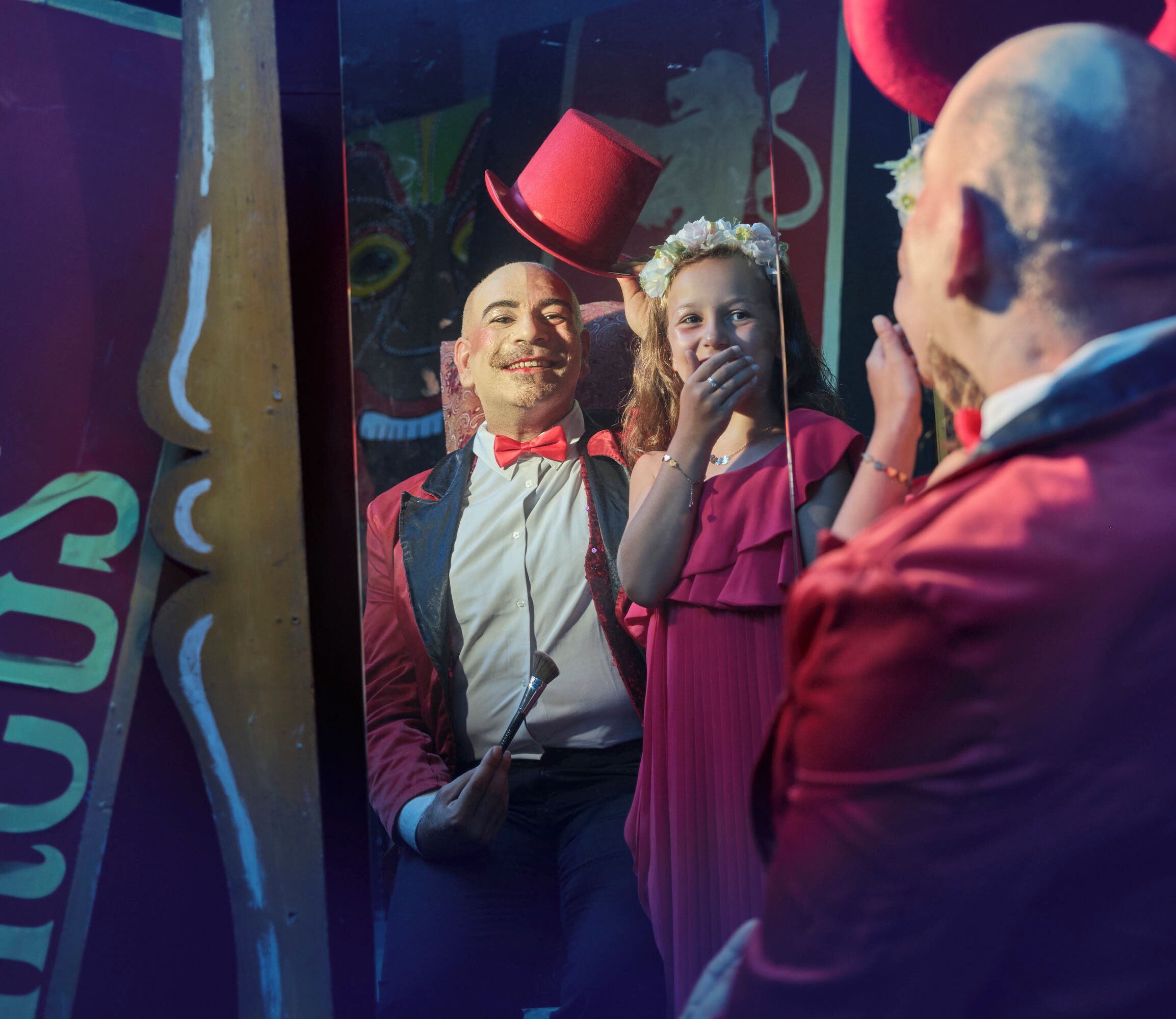 Spiegelbeeld van een persoon met een rode hoed en een vrouw in een roze jurk.