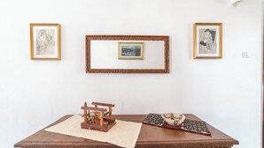 Una mesa de madera con un cuadro enmarco, otro cuadro más pequeño y una maqueta.