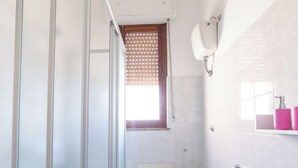 Un baño con cabina de ducha de vidrio, inodoro y bañera.