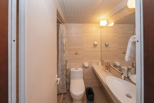 Un baño pequeño con inodoro, lavabo y espejo.